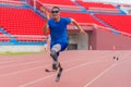 Willful Asian athlete speeds up on stadium track, aiming to break his record with prosthetic blades Royalty Free Stock Photo