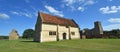 Willington Church, stables and Dovecote on a sunny day with blue sky and clouds.