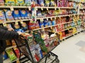 Wilmington, Delaware, U.S - January 8, 2022 - Pushing a cart filled with groceries on the snacks aisle inside a supermarket