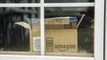 Wilson, NY, USA, July 2019: An open box from the parcel with the Amazon logo is visible outside the window. Royalty Free Stock Photo