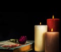 Wilted Faded red rose on book diary with three burning candles. Romantic Concept Royalty Free Stock Photo