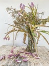 Wilted flowers bouquet in a clear glass vase