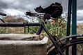 Wilted flowers in an old coffee bag hanging on a rusty bicycle Royalty Free Stock Photo