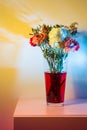 Wilted flowers in red water in colored light