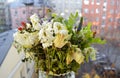A wilted frozen bouquet of white roses and chrysanthemums, greenery on open window against the background of the street and houses Royalty Free Stock Photo