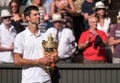 Novac Djokovic, Serbian player, wins Wimbledon for the fourth time. In the photo he holds the trophy on centre court.