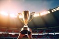 Win concept. Man holding up a gold trophy cup. Winner in a competition in night stadium. Generative AI. Royalty Free Stock Photo