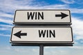 Win win road sign with two arrows on blue and grey sky background. White two street sign with arrows on metal pole. Two way road Royalty Free Stock Photo