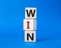 Win symbol. Wooden blocks with words Win. Beautiful blue background. Business and Win concept. Copy space Royalty Free Stock Photo