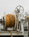 Winch with orange rope on a ferry, white cloudy backgrond