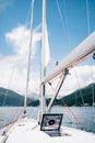 Winch of white sailing yacht with a red rope. Open glass hatch in the bow of the ship