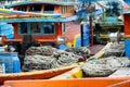 Winches and coiled ropes on colorful fishing boats moored next to each other