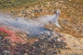 Winchester, CA USA - June 14, 2020: Cal Fire aircraft drops fire retardant on a dry hilltop wildfire near Winchester, California