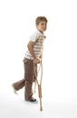 Wincing injured boy using crutches Royalty Free Stock Photo