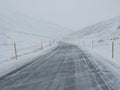 Wind blown snow covered winter road with mountain on the side of Royalty Free Stock Photo