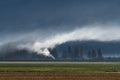 Wind blown white smoke drifting through a valley