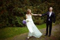 Wind blows away bride's dress while she walks along the path hol