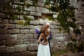 Wind blows away bride's hair while groom hugs her under the tree