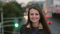 Wind blows long hair beautiful young women. smiling girl standing on the bridge in the evening and looks at camera. 4K Royalty Free Stock Photo