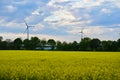 Wind electric generators against a field of flowering rapeseed Royalty Free Stock Photo