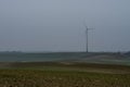 Wind farm in the distance on an empty field. Windmill producing