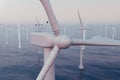 Wind farm turbines caught in sunset sky. Beautiful contrast with the blue sea. ecological concept. 3d rendering Royalty Free Stock Photo