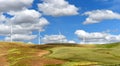 Wind farm turbines white on hill contrast green grass and blue sky, wa Royalty Free Stock Photo