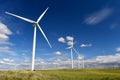 Wind farm turbines white on hill contrast green grass and blue sky, wa Royalty Free Stock Photo