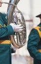 A wind instrument parade - a man in green costume playing tuba