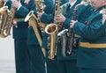 A wind instrument parade - people in green costumes playing saxophone