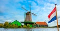 Wind mill, old house and the flag of the Netherlands are popular Dutch icons. Landscape, panorama. Amsterdam, Holland, Netherlands Royalty Free Stock Photo