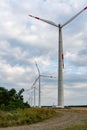 Wind power complex of Rosatom.Towers of wind turbines with rotating blades at sunset against cloudy sky. Royalty Free Stock Photo