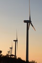 Wind power generator lined up at dusk or sunset making silhouette effect.