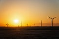 Wind power plants in desert at sunset Royalty Free Stock Photo