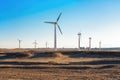 Wind power plants in desert at sunset Royalty Free Stock Photo