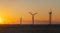 Wind power plants in desert at sunset Royalty Free Stock Photo