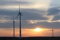 Wind power station in the sunset. Rotating blades of energy generators. Ecologically clean electricity. Modern technologies for t Royalty Free Stock Photo