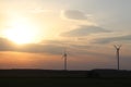 Wind power station in the sunset. Rotating blades of energy generators. Ecologically clean electricity. Modern technologies for t Royalty Free Stock Photo