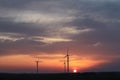 Wind power station in the sunset. Rotating blades of energy generators. Ecologically clean electricity. Modern technologies for t Royalty Free Stock Photo