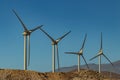 Wind power stations. A row of turbines near the seashore. Wind farm eco field. Eolic park with blue sky in background. Green, Royalty Free Stock Photo