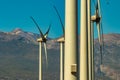 Wind power stations. A row of turbines near the seashore. Wind farm eco field. Eolic park with mount Teide and blue sky in Royalty Free Stock Photo