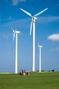 Wind power and tractor. Royalty Free Stock Photo