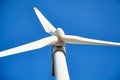 Wind power turbine against a blue sky background. White blades of a wind generator closeup. Renewable energy source. Royalty Free Stock Photo