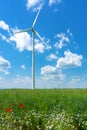 Wind power wheels on a wild flower field with nice blue sky Royalty Free Stock Photo