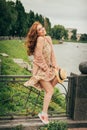 the wind raises the skirt of the dress, the girl is surprised and confused. beautiful red-haired girl.picture against the backgrou