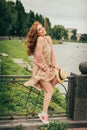 the wind raises the skirt of the dress, the girl is surprised and confused. beautiful red-haired girl.picture against the backgrou Royalty Free Stock Photo