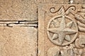 A wind rose or compass rose element decorative relief cut in sandstone.