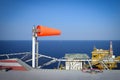 The wind sock is set on the oil rig to showing wind direction for helicopter ... Royalty Free Stock Photo