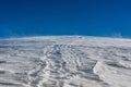Wind storming and moving snow with a blue sky background, Passo Giau, Cortina d`Ampezzo, Dolomites, Italy Royalty Free Stock Photo