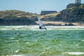 Wind surfer enjoys the beach at Newborough Warren with the Island of Llanddwyn in the background , Isle of Anglesey Royalty Free Stock Photo